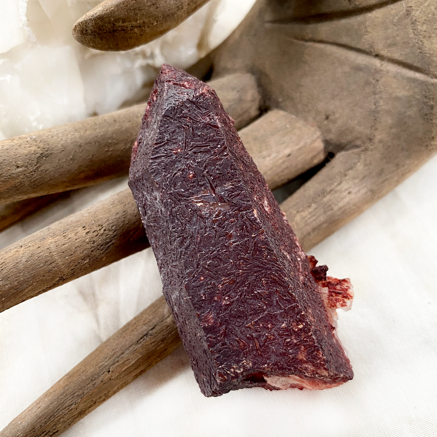 Raw naturally etched Quartz point encrusted with Hematite