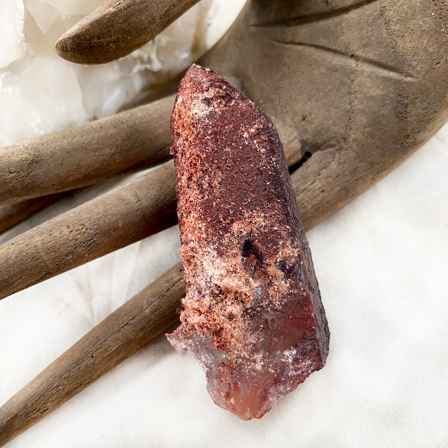Raw naturally etched Quartz point encrusted with Hematite